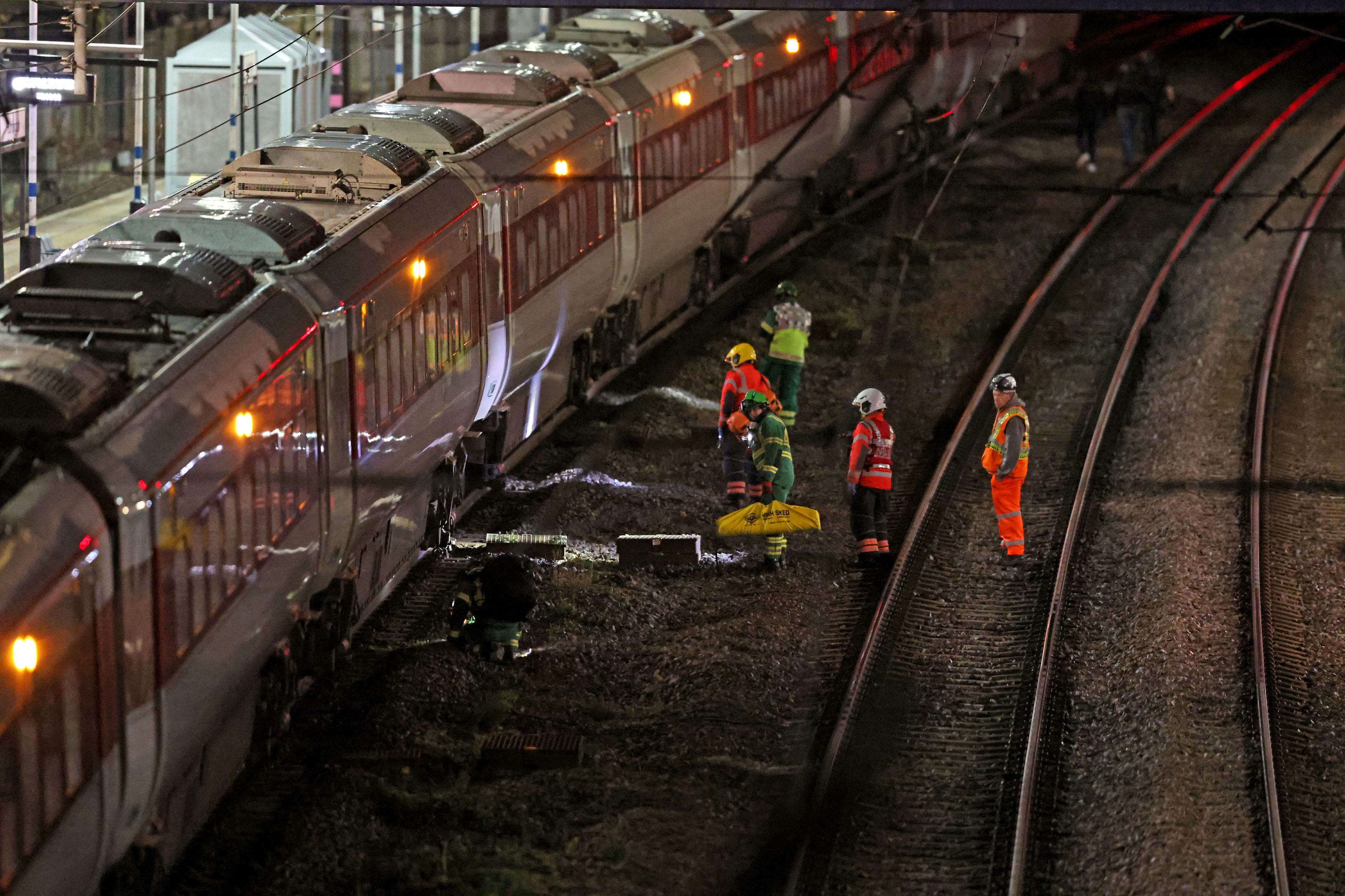 Emergency personnel inspect a train at the Huntingdon, England, train station in Cambridgeshire after people were stabbed Saturday, Nov. 1, 2025.